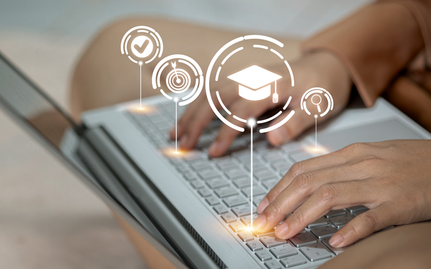 Hands typing on a laptop keyboard with digital education icons overlaid.